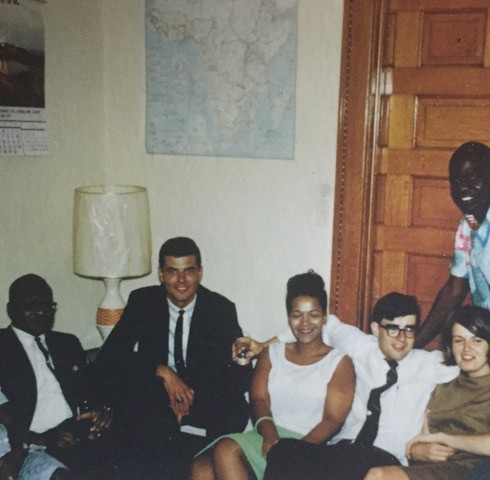 Image of a salon in 1960's Akron, Ohio featuring women and men of various races.